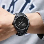 Modern black smartwatch with an upside-down digital display worn on a person's wrist, showcasing a sleek design and innovative time presentation.