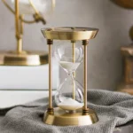 Vintage brass hourglass with white sand, ideal for decor and educational purposes, showcasing classic time-measuring design.