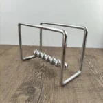 Classic Newton's Cradle with metal balls demonstrating physics principles, perfect for science decor and educational purposes.