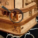 Magnifying glass focusing on wooden puzzle pieces, highlighting the intricate craftsmanship and educational value of the game.