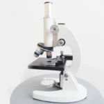 High-quality white laboratory microscope with adjustable focus and multiple objective lenses for detailed scientific study.