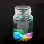Transparent glass jar filled with a colorful magnetic liquid and magnetic rocks, showcasing a science experiment or decorative science gadget.