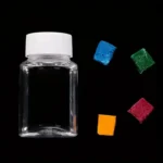 Clear glass jar with colorful sugar cubes (blue, green, red, orange) on black background, ideal for science decor and educational displays.