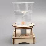 A clear water tank with a floating object powered by a small motor, demonstrating principles of buoyancy and electromagnetism.