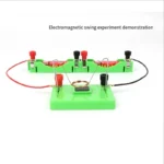 Electromagnetic swing experiment demonstration with colorful components on a green base, illustrating magnetic forces and electromagnetic principles for educational purposes.