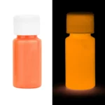 Fluorescent orange ink vial glowing in the dark, showcasing luminescent properties for science experiments and educational demonstrations.