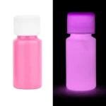 Small pink bottle of UV-reactive glow-in-the-dark paint, shown under normal and black light to demonstrate luminous effect.