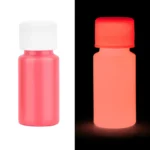 Glow-in-the-dark pink paint bottle glowing in the dark, showcasing luminous effect for science experiments and creative projects.