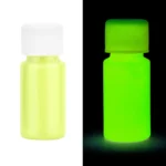 Small glow-in-the-dark paint bottle glowing green in the dark, showcasing its luminous properties for science experiments and educational activities.