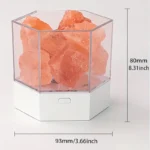Salt rock lamp in a hexagonal glass container with a white base, measuring 80mm in height and 93mm in width, creating a warm, ambient glow.