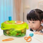 Young girl observing a small indoor aquarium with colorful fish and aquatic plants, educational science toy for children.