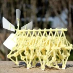 Detailed plastic animal model resembling a cow, used for educational purposes and science decor, featuring interconnected parts and a windmill tail.