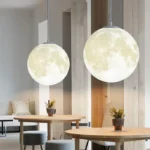 Two moon-shaped pendant lights hanging over a cozy dining area, creating a celestial ambiance in a modern home interior.