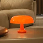 Bright orange mushroom-shaped table lamp providing ambient lighting for living rooms or bedrooms.