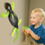 Young boy playing with a robotic lizard toy on the wall, demonstrating interactive and educational science gadgets for children.