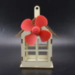 Miniature windmill model with red blades and a small house structure, ideal for science projects, educational demonstrations, or decorative purposes.