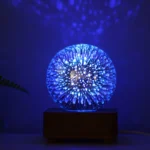 Illuminated fiber optic sphere emitting blue light with star-like patterns, creating a mesmerizing glow in a dark room.