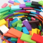 Brightly colored chalk pieces in various shades including green, purple, orange, blue, black, and white, arranged in a pile.