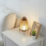 Stylish wooden bedside lamp emitting a cozy glow on a white nightstand.
