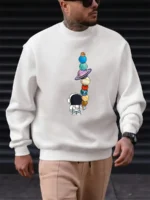Sweat-shirt avec illustration d'un explorateur spatial regardant une tour de planètes en équilibre.
