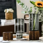 Modern glass vase with a wooden base, perfect for displaying flowers like sunflowers and eucalyptus, ideal for home decor and floral arrangements.