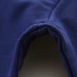 Blue fabric close-up, showcasing detailed stitching and texture.