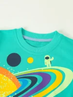 Astronaut and colorful space-themed design on a turquoise T-shirt, featuring planets, stars, and a playful astronaut figure, perfect for science enthusiasts and educational toy lovers.