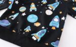 Colorful space-themed fabric featuring rockets, planets, stars, and moons, perfect for science decor and educational toys.