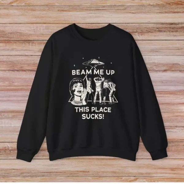 Black sweatshirt featuring a humorous sci-fi design with a girl, aliens, and spaceship, with the text "BEAM ME UP THIS PLACE SUCKS!" for science and space enthusiasts.