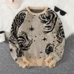 Cozy beige knit sweater with black celestial and galaxy patterns, featuring stars, moons, and swirling designs, perfect for casual wear and star-gazing nights.