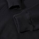 Black hoodie with ribbed cuffs and collar, close-up view.
